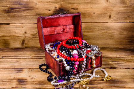 Old box of red wood full of jewelry. Treasure chestの写真素材