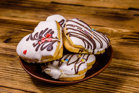 Cookies made in shape of heart on wooden background