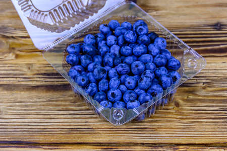 Blueberry in plastic box on wooden tableの写真素材