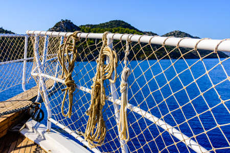Ropes hanging on railings at yacht bowの写真素材