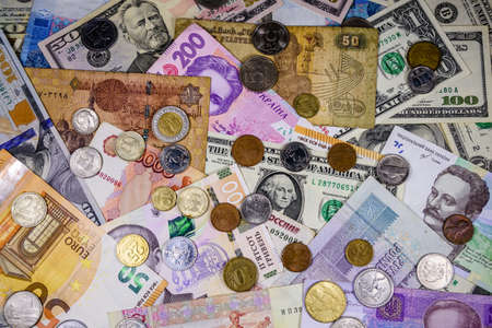 Multi currency background. Euro, american dollars, ukrainian hryvnias, egyptian pounds, russian roubles and different coinsの写真素材