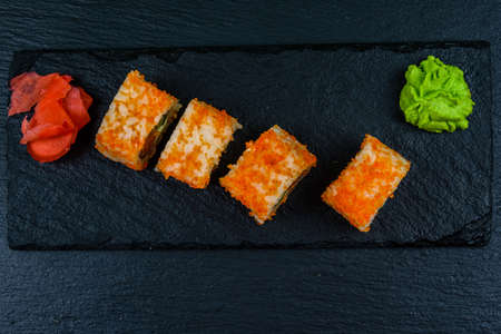 Sushi roll philadelphia with salmon, rice, cheese, cucumber, avocado and caviar on slate board. Japanese food. Top viewの写真素材