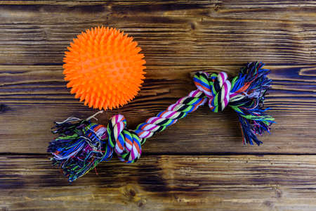 Dog rope toy with tied knots and toy ball on wooden background. Top viewの写真素材