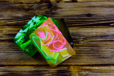 Pieces of handmade soap on wooden background. Top view