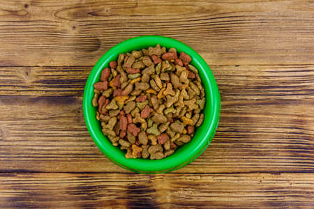 Bowl with pet food on wooden background. Top viewの写真素材
