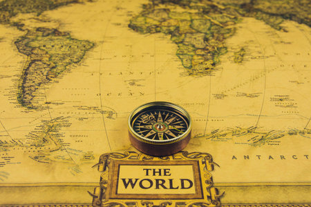 Compass on old map of world. Journey and discovery concept