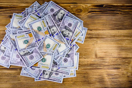 Heap of one hundred dollar banknotes on wooden background. Top viewの写真素材