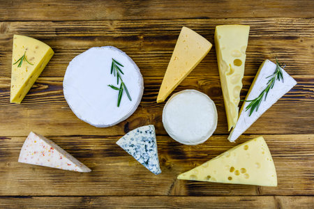 Various types of cheese on wooden background. Top viewの写真素材