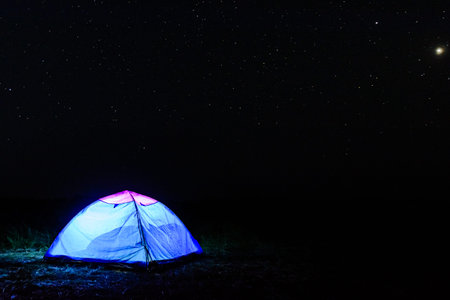 Tourist tent at night. Night sky with many starsの写真素材