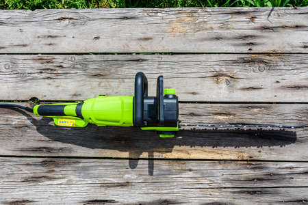 New electric chain saw on wooden table. Top viewの写真素材