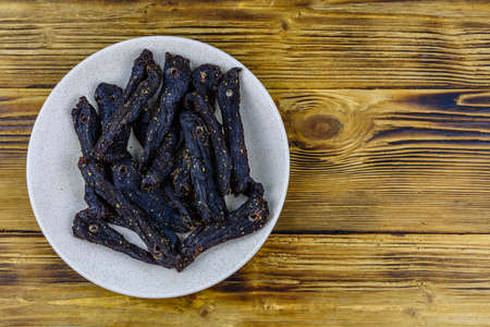 Plate with south african dried meat biltong on a wooden table. Top viewの写真素材