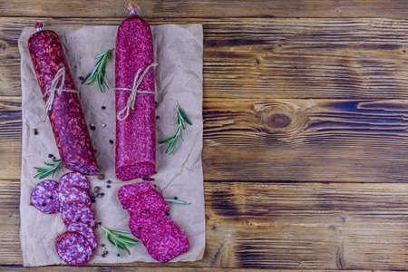 Dry smoked salami sausage on wooden background. Top viewの写真素材