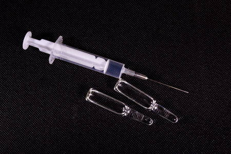 Syringe on black background. Healthcare and medicine concept. inscription
