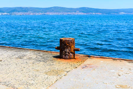 Old rusty mooring bollard at the pierの写真素材