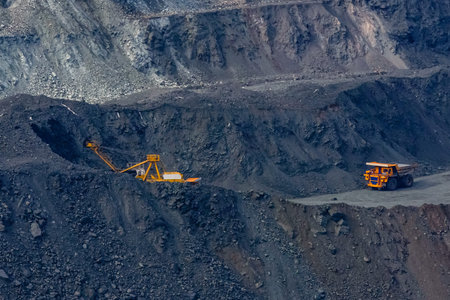 Huge empty dump truck on gravel road in iron ore quarry