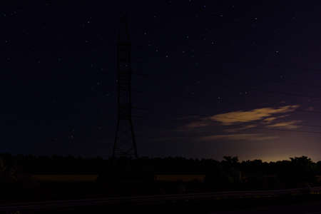 High voltage power line in a field at night. Star sky on backgroundの写真素材
