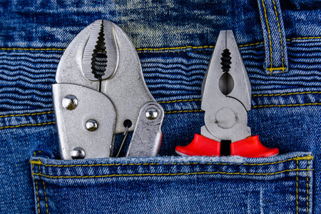 Pliers and locking pliers in rear pocket of jeans. Top view