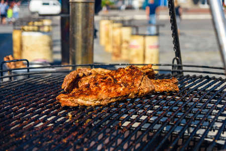 Piece of meat cooking on metal grate grillの写真素材