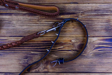 Brown leather dog leash and collar on wooden background. Top viewの写真素材