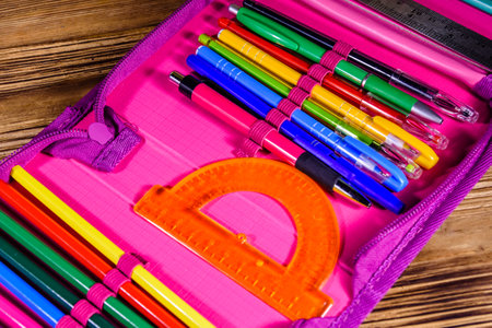 Different school stationeries (pens, pencils, ruler and protractor) in pink pencil boxの写真素材