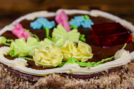 Kiev cake with cream, nuts and meringue in cardboard box on wooden table