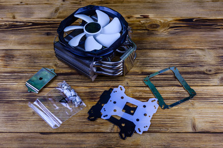 Modern cpu cooler with heat pipes and installation kit on wooden backgroundの写真素材
