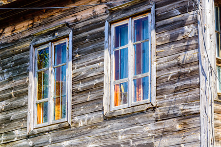 Window in wooden wall of ancient residential buildingの写真素材