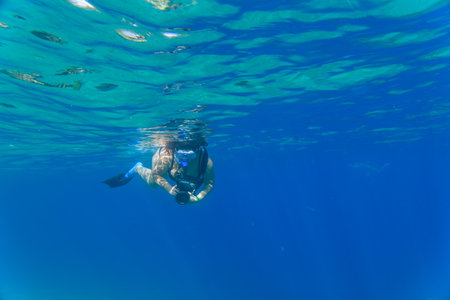 Young woman snorkeling in Red sea with cameraの写真素材