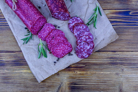 Dry smoked salami sausage on wooden background. top viewの写真素材