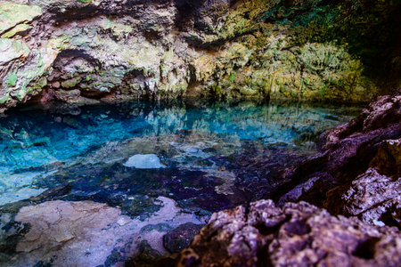 Stalagmites and stalagmites in Kuza cave at Zanzibar, Tanzania. Natural pool with crystal clear waterの写真素材