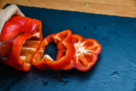 Woman cutting bell pepper on cutting boardの写真素材