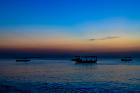 Traditional tourist boats at Indian ocean when sunset. Zanzibar, Tanzania