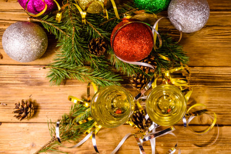 Two wineglasses with champagne and different christmas decorations on rustic wooden table. Top viewの写真素材