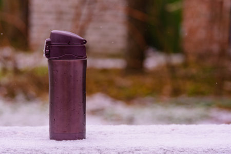 Jug with hot coffee on wooden table in winterの写真素材