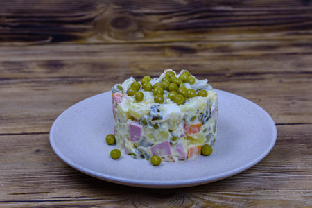 Ceramic plate with new year salad olivier on wooden tableの写真素材