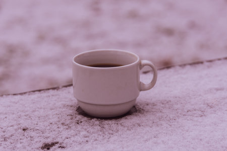 Cup with hot coffee on wooden table in winterの写真素材