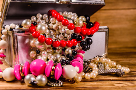 Aluminum case full of different jewelry on rustic wooden tableの写真素材