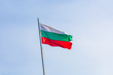 Bulgarian national flag waving in blue skyの写真素材