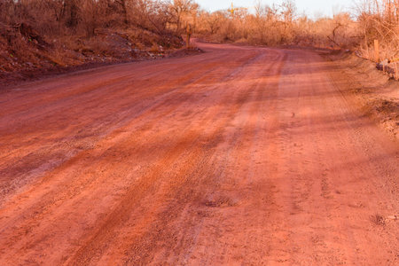 Red dirt road polluted with iron ore. Environmental pollutionの写真素材