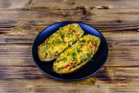 Plate with baked stuffed eggplants on wooden tableの写真素材