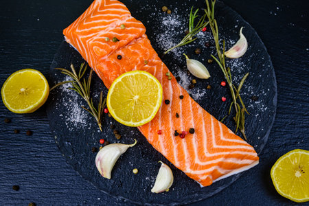 Raw fillet of salmon fish and spices on slate boardの写真素材