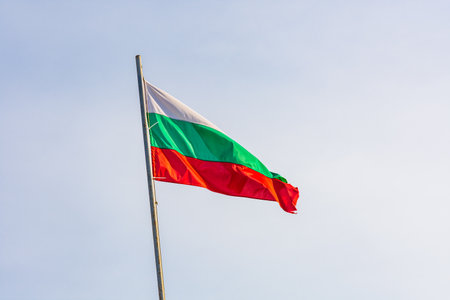 Bulgarian national flag waving in blue skyの写真素材