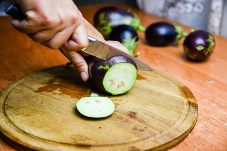 Woman cutting eggplant on a cutting boardの写真素材
