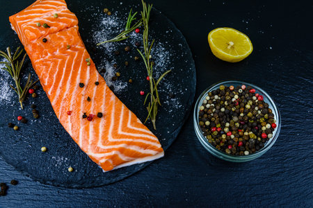 Raw fillet of salmon fish and spices on slate boardの写真素材