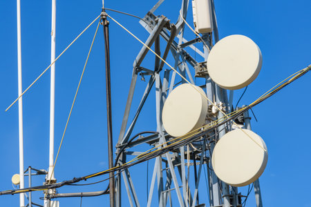 Telecommunication antennas and wireless communication antenna transmitter against blue skyの写真素材