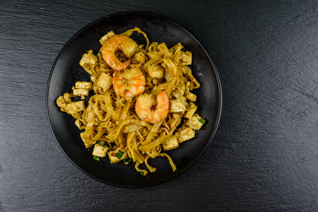 Black plate with pad thai on slate board. top viewの写真素材