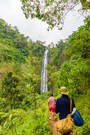 Tourists walk to Materuni waterfall at foot of mountain Kilimanjaro not far from city Moshi, Tanzaniaの写真素材