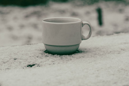 Cup on wooden table in winterの写真素材