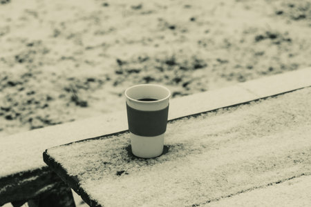 Cup with hot coffee on wooden table in winterの写真素材