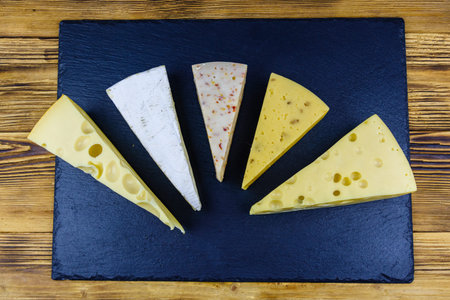 Various types of cheese on slate board. Top view